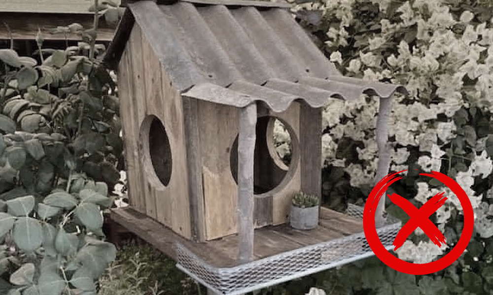 A weathered decorative birdhouse mounted on a post
